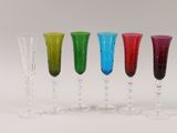 four different colored wine glasses are lined up in a row