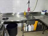 a kitchen with a sink and a trash can in it