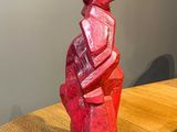 a red sculpture sitting on a wooden table