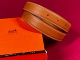 two belts and a box on a pink surface