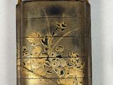 a small gold case with flowers and birds on it