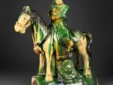 figurine of a man on a horse with a dragon on the back