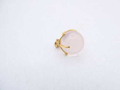 a white stone ring with a gold band on a white surface
