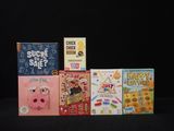several children ' s books are lined up on a black surface