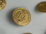 several gold coins with the number 14 on them on a white surface