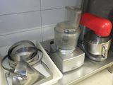 trois robots ménagers posés sur une étagère métallique dans une cuisine