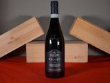 a bottle of wine sitting on a table next to a wooden box