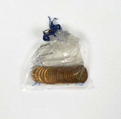 a bag of coins sitting on top of a white table