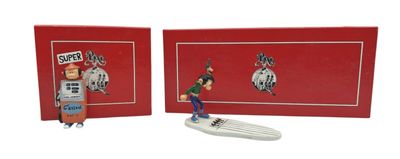 two figurines of a man on a surfboard in front of a red box