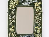 un petit miroir carré orné d'un motif d'oiseau