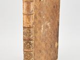 an old book sitting on top of a table next to a white wall