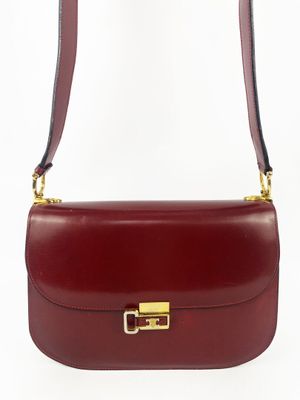 un sac à bandoulière en cuir rouge avec un fermoir doré