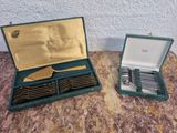 deux sets d'argenterie dans un coffret sur une table
