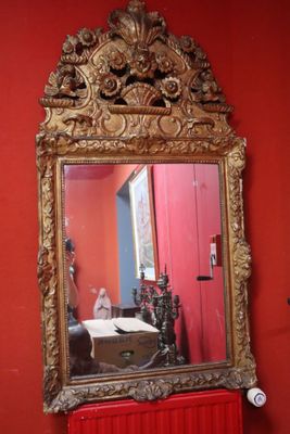 a mirror on the wall above a red radiator