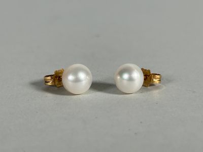 a pair of pearl stud earrings on a white surface