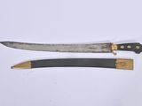 pair of two knives on a white surface one has a black handle and the other has a gold handle