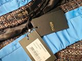 a close up of a blue and black jacket with a tag on it