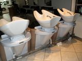 four toilets lined up in a row in the bathroom