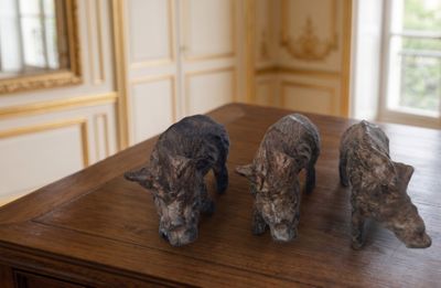 trois figurines de chiens posées sur une table dans une pièce