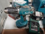 une perceuse bleue et deux autres outils posés sur une table