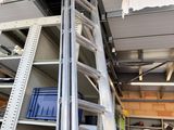 a man that is standing on a ladder in a garage