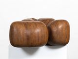 a wooden sculpture on a white pedestal with a white background