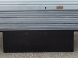 une table noire à pied carré posée sur le sol en béton