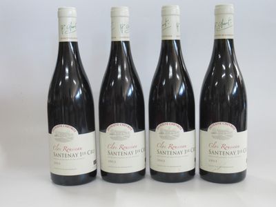 four bottles of red wine are lined up on a white surface