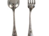 two silver spoons and a fork sitting next to each other