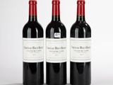 trois bouteilles de vin rouge posées sur une table