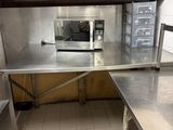 a small kitchen with stainless steel counter tops and a microwave