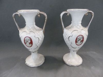 deux vases blancs posés l'un à côté de l'autre sur une table