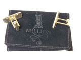 two gold cufflinks on a black velvet pouch with a one million sign on it