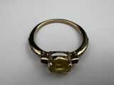 a close up of a ring with a yellow stone on it