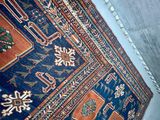 a blue and orange rug on the floor in a room