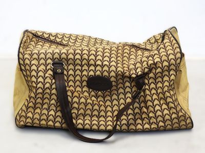 un sac à main marron et noir posé sur une table blanche