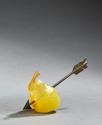 a yellow apple with an arrow stuck in the middle of it