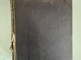 an old book with a pink sticker on it sitting on top of a table