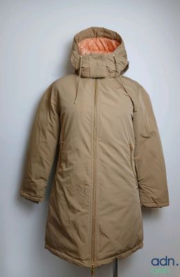 une veste posée sur un mannequin adossé à un mur blanc