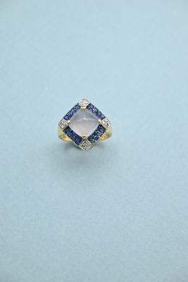 a diamond and sapphire ring on a blue surface