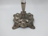 an antique silver candle holder with a glass candle on top