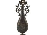 une image représentant un vase en métal orné de fleurs, sur fond blanc