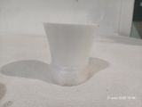 une tasse blanche posée sur une table blanche