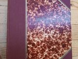 un livre rouge et blanc posé sur une table en bois