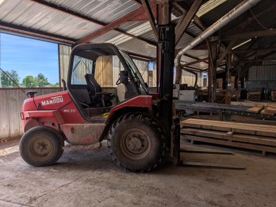 un chariot élévateur rouge garé dans un entrepôt