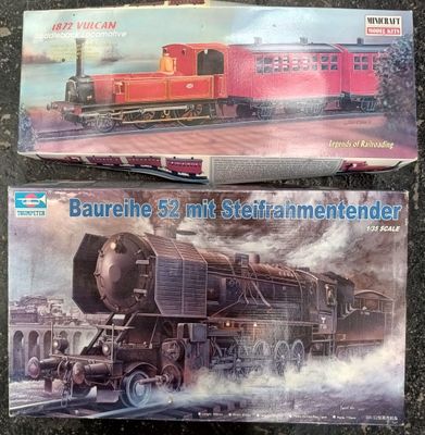 two model trains sitting on a table next to each other