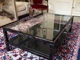 a living room with a rug and a glass coffee table