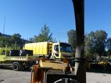 a yellow truck that is parked in the dirt