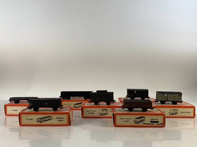 six toy trains are lined up in a row on a white surface