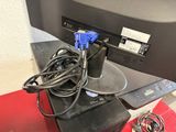 a computer monitor with a cable connected to it on a desk
